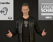 Zauberer in schwarzer Lederjacke vor Badische Zeitung Podcast Logo und SWR Fernseh- Logo